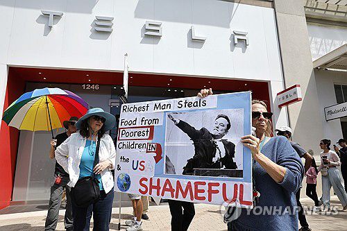 지난 5일(현지시간) 캘리포니아 테슬라 매장 앞에서 머스크 비판하는 피켓 든 시위자. EPA 연합뉴스